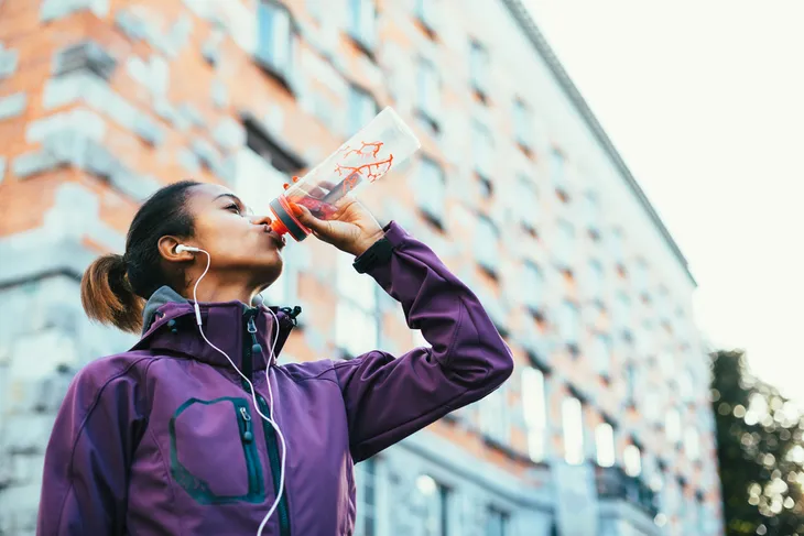 Woman drinking water out of a bottle 