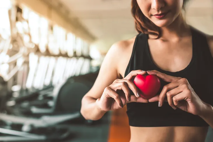 Athletic woman holding a heart 