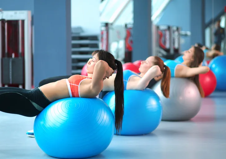 Group of women performing crunches on an exercise ball