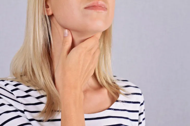 Woman feeling tumor in neck