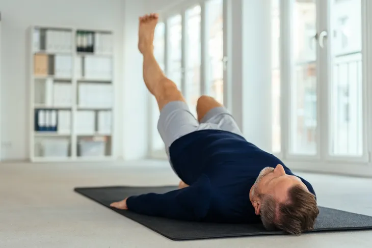 man performing leg strengthening exercise, leg raises