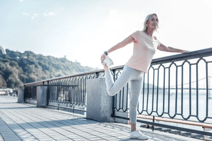 woman performing standing knee flexion exercise