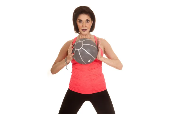 Woman standing with medicine ball