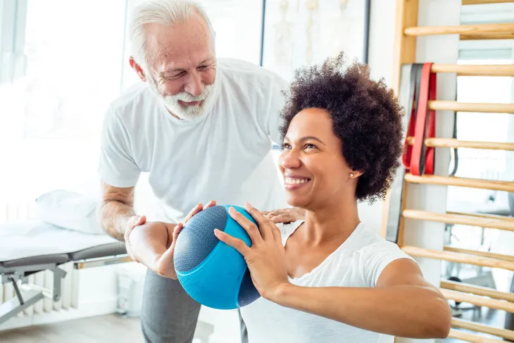 senior woman doing chest press with a medicine ball