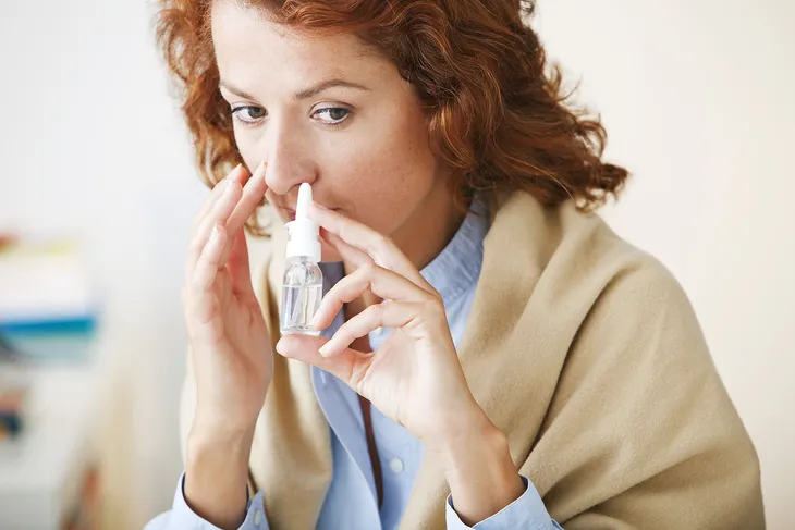 woman using nasal spray