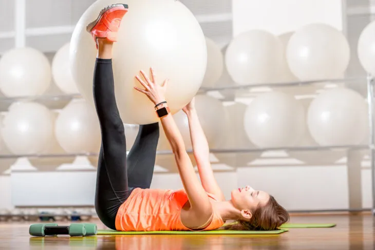 woman holding stability ball in the air