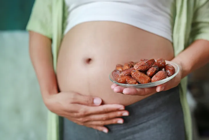 pregnant woman holding dates