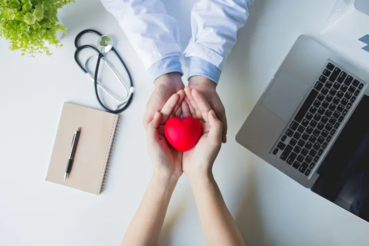 doctor and patient holding hands with heart