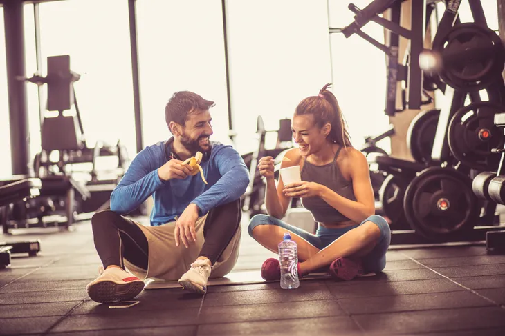 Couple eating healthy snacks in the gym