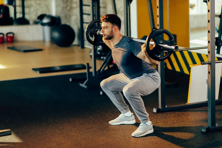 Man doing barbell squats